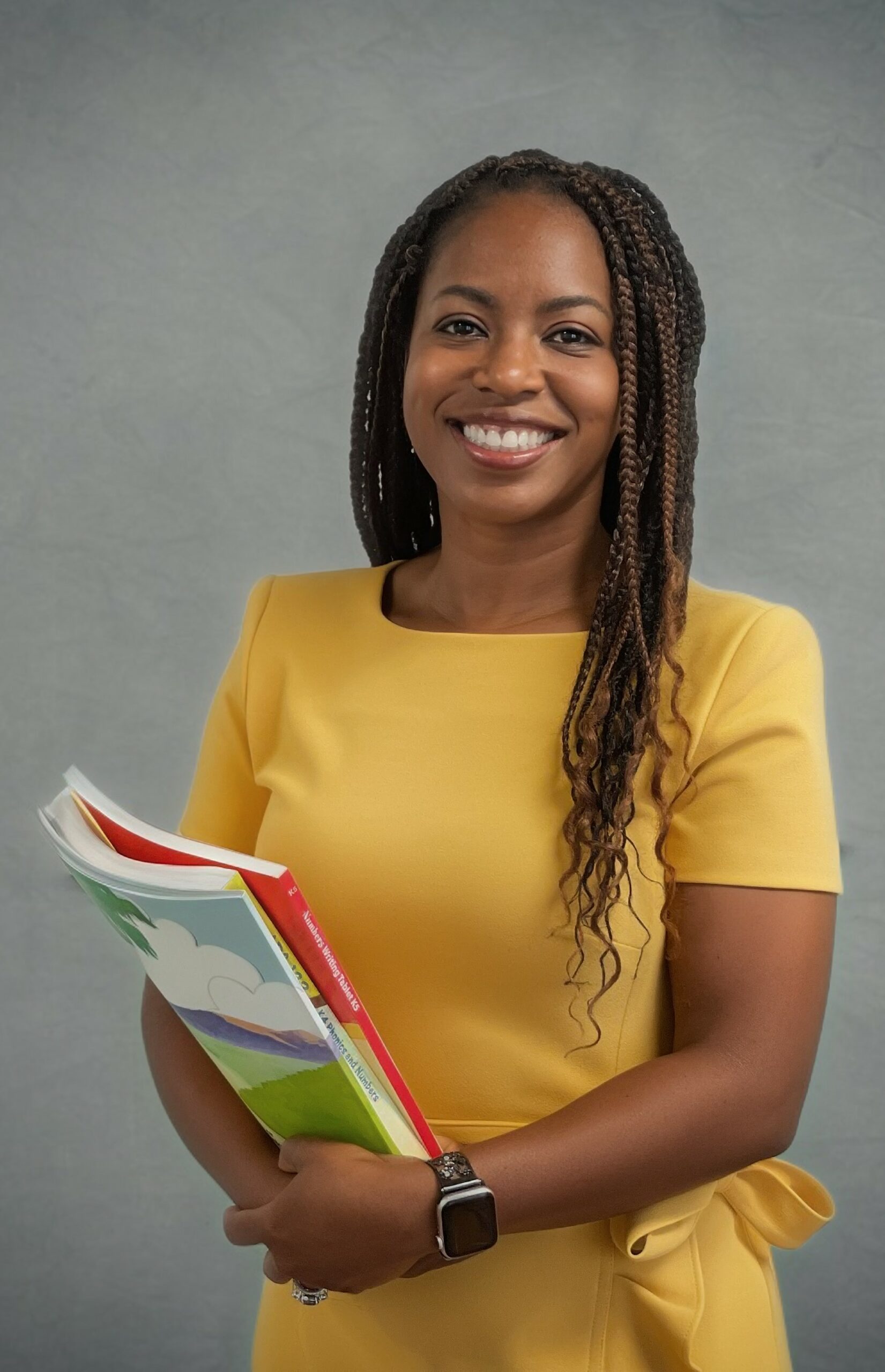 Yvonne Miller Yellow Dress Standing School Books Gray Background